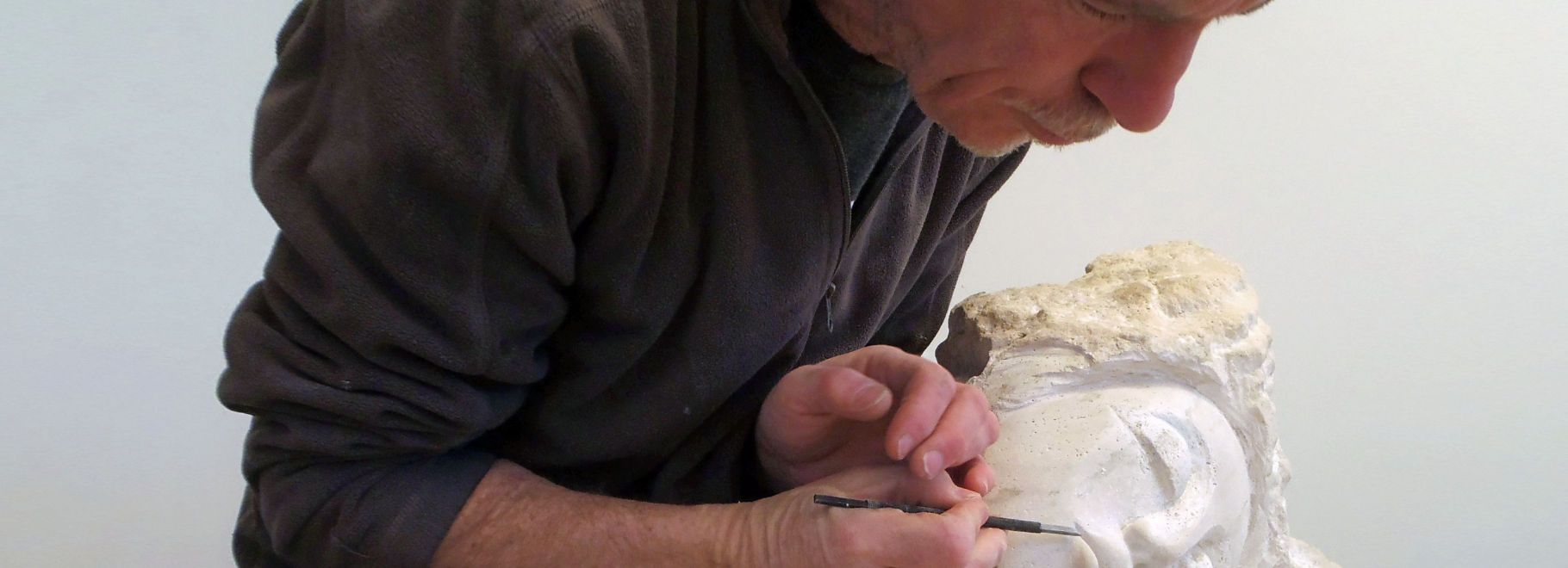 Chris Beaudry working in stone. Carving / sculpting in the studio. A photo detail.